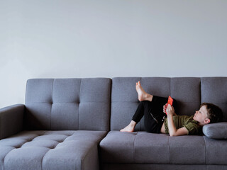 child lying on the sofa with the telephone