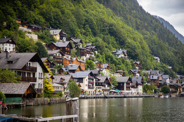 Fototapeta na wymiar old austrian mountain village on mountain slope with lake and reflection