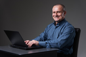 Mature businessman at his desk on his laptop