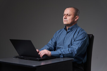 Mature businessman at his desk on his laptop