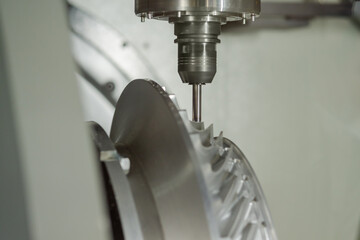 Automated cnc vertical turning milling machine cutting metal workpiece at factory, exhibition, plant - close up. Industrial, metalworking, engraving, equipment, technology and manufacturing concept