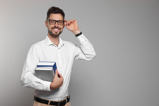 Happy teacher with glasses and books against beige background. Space for text