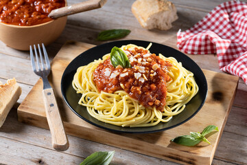 Spaghetti with bolognese sauce on wooden table.