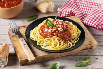 Spaghetti with bolognese sauce on wooden table.