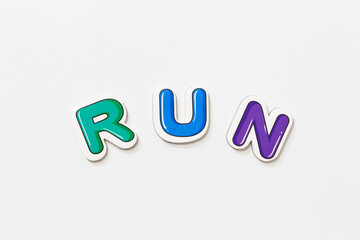 Colorful funy lettering fridge magnets with 'RUN' lettering on isolated white background.