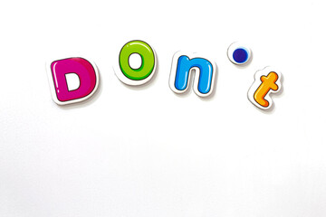 Colorful funy lettering fridge magnets with 'Don't' lettering on isolated white background.