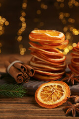 Dry orange slices, anise stars and cinnamon sticks on wooden table. Bokeh effect