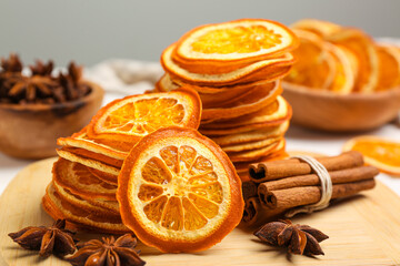 Dry orange slices, anise stars and cinnamon sticks on wooden board, closeup