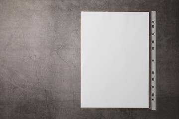 Punched pocket with paper sheet on grey table, top view. Space for text
