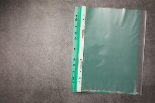 File folder with punched pockets on grey table, top view. Space for text