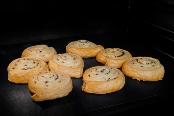 Eight baked buns with poppy seeds on tray in electric oven. Homemade bakery, food, cooking and pastry concept