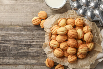 Bowl of delicious nut shaped cookies on wooden table, flat lay. Space for text