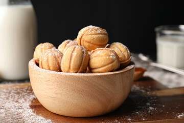 Delicious nut shaped cookies with powdered sugar on wooden table, closeup. Space for text