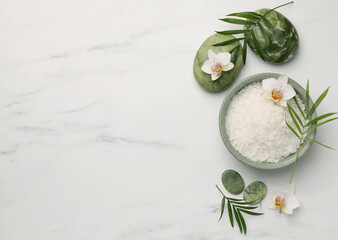 Flat lay composition with spa products and flowers on white marble table. Space for text