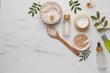 Flat lay composition with different spa products on white marble table. Space for text