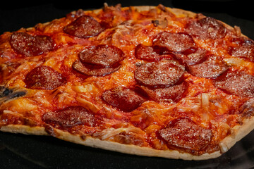 Macro: burnt pizza with pepperoni, cheese, sause on tray in electric oven - close up. Italian cuisine, homemade bakery, failure, problem concept