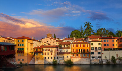 Bassano Del Grappa, Veneto Region, Italy. Ancient italian houses on river Brenta. Panoramic view at old town with vintage buildings of scenic sunset landscape