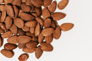 Close-up of brown almond nuts on a white isolated background. Image for your design
