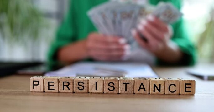 Business woman counts dollar bills and text on cubes is insistent.