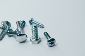 Set of bolts on a white background. Construction abstraction. Industrial background. Screws and bolts macro photo, screw background, steel screw, bolt macro.