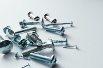 Set of bolts, screws, nails on a white background. Construction abstraction. Industrial background. Screws and bolts macro photo, screw background, steel screw, bolt macro.