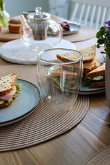 Unwind and Relax with a Delicious Afternoon Tea Time Selection - Enjoy Fresh and Flavorful Sandwiches Served in a Thermoglass at a Beautifully Set Dining Table