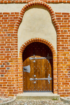 Olsztyn, Poland, August 10, 2022. Entrance to Warmian Chapter Castle from courtyard. Construction of castle began in 1348, and 30-meter round tower with southern wing was added in 15th century.