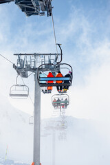 Skiing Getaway: Unrecognizable Group of Four on a Chairlift to the Slopes