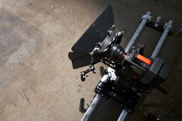on the camera trolley and rails there is a professional movie camera with a full body kit. camcorder before filming