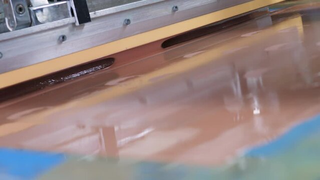 screen printing. silkscreen. the master applies paint through a stencil. product coloring. production