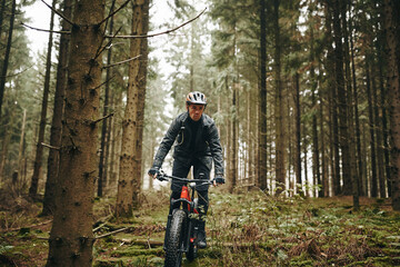 Man riding his mountain bike along a rugged forest trail