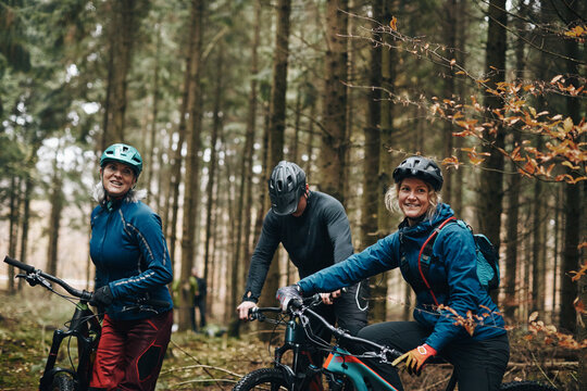 Smiling friends out mountain biking together in the forest