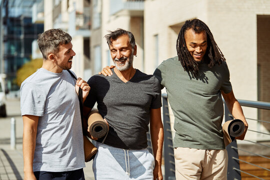 Smiling group of men walking outside after a gym session