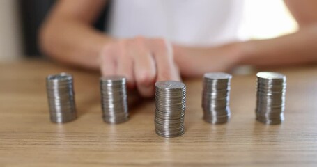 Businesswoman moves stacks of coins financial income growth
