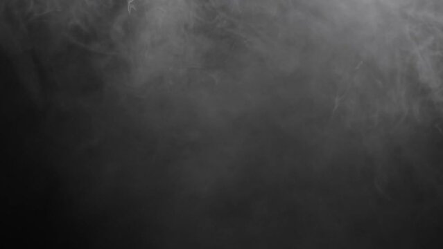 Slow motion of white smoke, fog, mist, vapor on a black background