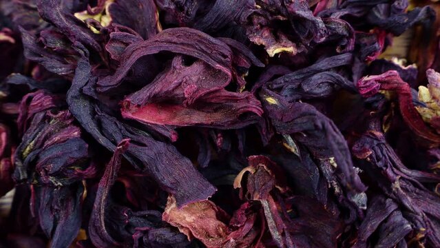 Top view of bright pink dried hibiscus tea leaves circle rotation close up