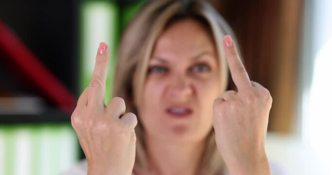 Portrait of angry aggressive woman showing fuck you gesture