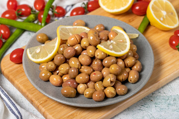 Scratched green olives. Brined scratched green olives on a wood serving board. Close up