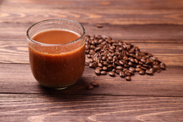 Hot coffee mug and beans on wooden table