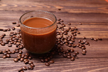 Hot coffee mug and beans on wooden table