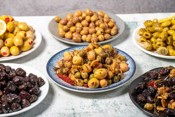 Olive varieties. Assortment of black and green olives on plate on gray background