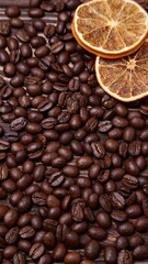 Roasted coffee beans and dried orange background