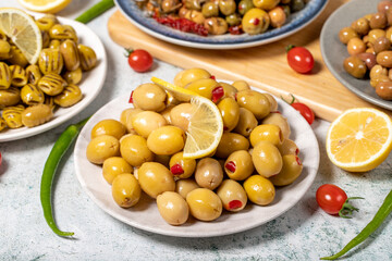 Olive varieties. Assortment of black and green olives on plate on gray background