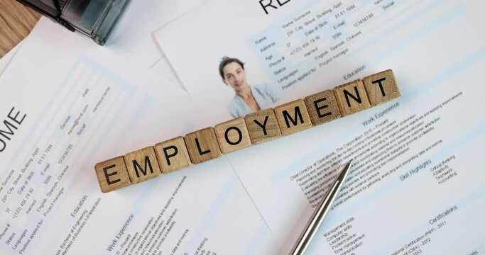 Stack of office documents and resume on table text employment