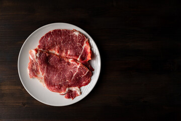Iberian pork fillets on white plate and wood