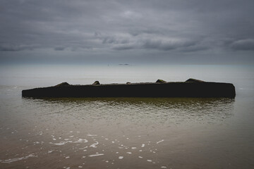 Old shipwrech from world war Two, at the coast of Utah Beach, France.