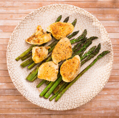 cooked dish. Chicken nuggets with green asparagus on plate