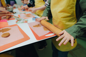 The child prepares lazy dumplings in the kitchen. Children's cooking. Board for rolling dough, flour, dough, dumplings on the table.