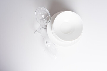 Stacked white clean plates and cups on white table