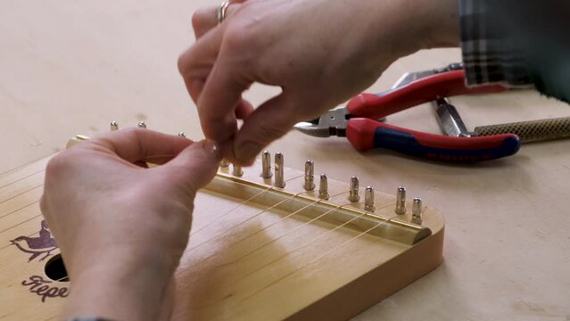 Gusli is an ancient folk Slavic instrument. production. a worker tunes the strings. close-up. 4k